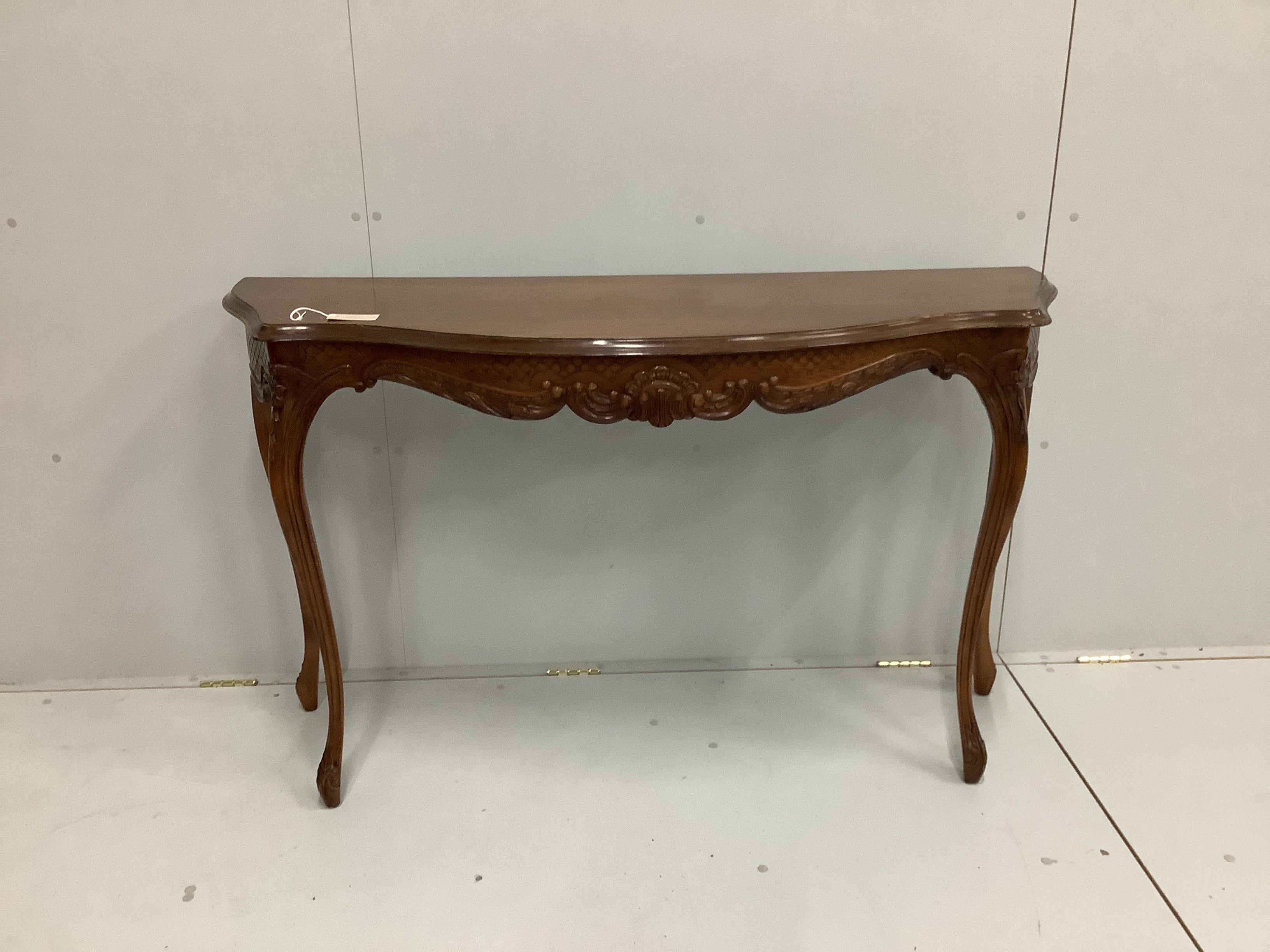 A reproduction serpentine fronted console table, with carved frieze, on cabriole legs, width 136cm, depth 45cm, height 83cm